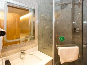 een badkamer met douche, wastafel en spiegel bij GreenTree Inn Xingtai City Neiqiu County 107 National Road Business Hotel in Xingtai
