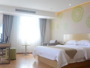 a bedroom with a large white bed and a television at GreenTree Inn LuAn Yeji District Yeji Railway Station Express Hotel in Sifangtang