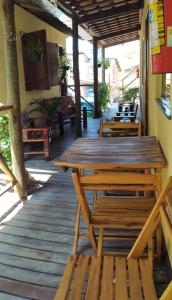une table en bois et des bancs sur une terrasse dans l'établissement Chalés Pulo do Gato, à Canoa Quebrada