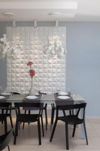 una sala da pranzo con due tavoli e un vaso con fiori di Villa VinSun a Vinišće