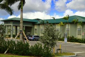 a building with a car parked in front of it at Pioneer Inn in West Palm Beach