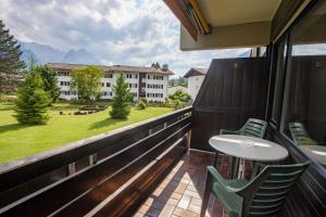 a balcony with two chairs and a table and a building at Alpenglück Whg. 20 in Garmisch-Partenkirchen