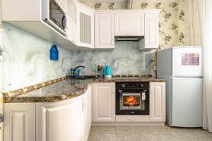 アスタナにある"7 Я-41" Apartmentのキッチン(白いキャビネット、コンロ付)