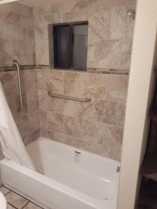 a bath tub in a bathroom with a shower at Stagecoach Suites in Wickenburg