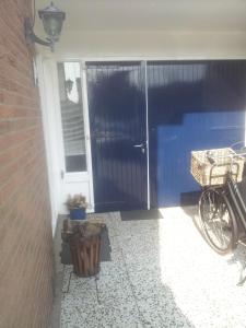 eine Haustür eines Hauses mit einem Fahrrad daneben in der Unterkunft Studio de Aankomst in De Koog