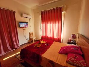 a bedroom with a large bed with red curtains at Joya Apartmento in Cairo