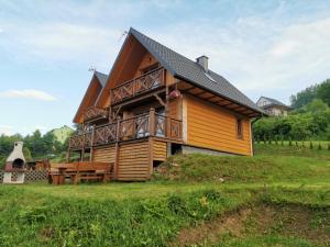 a large wooden house with a deck on a hill at Stare Zabrodzie in Solina