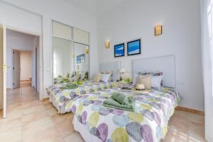 a bedroom with two beds with towels on them at Villa Aloe con piscina climatizada, Playa Fañabe, Costa Adeje in Adeje +13 photos