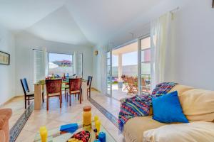 ein Wohnzimmer mit einem Sofa und einem Tisch in der Unterkunft Villa Aloe con piscina climatizada, Playa Fañabe, Costa Adeje in Adeje