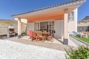 eine Terrasse mit einem Tisch, Stühlen und einem Grill in der Unterkunft Villa Aloe con piscina climatizada, Playa Fañabe, Costa Adeje in Adeje