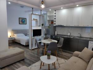 a kitchen and a living room with a couch and a table at E&A Apartments Guesthouse in Durrës