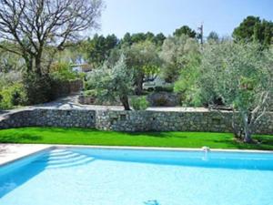 een zwembad in een tuin met een stenen muur bij Villa la Grette in Fayence