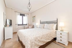 1 dormitorio blanco con 1 cama y TV en Fee4Me First Line Luxury apartment, en Arrecife