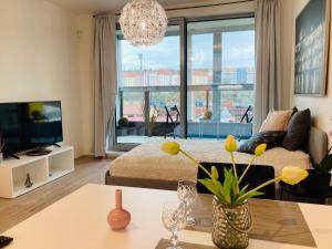 ein Wohnzimmer mit Couch und großem Fenster in der Unterkunft Apartement Blanc Harfa design in Prag