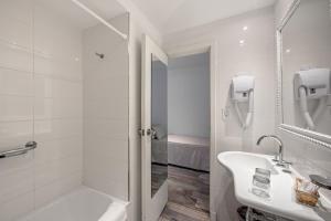 
a bathroom with a tub, sink, toilet and bathtub at Sennac Hotel in Mar del Plata
