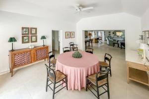 a dining room with a pink table and chairs at Coral Sea private beachfront panorama with infinity pool in Tuckerʼs Town