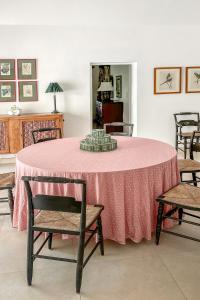 una sala da pranzo con tavolo rosa e sedie di Coral Sea private beachfront panorama with infinity pool a Tuckerʼs Town