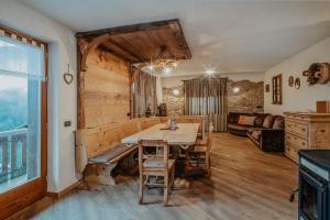 a dining room with a table and a couch at Pradella Apartments in Valdidentro