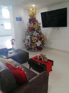 a living room with a christmas tree and a couch at HOTEL TANIA in Caucasia