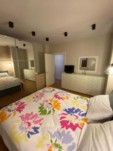 een slaapkamer met een bed met een bloemendeken erop bij Mel’s Place in Tirana