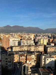 een stad met gebouwen en bergen op de achtergrond bij Mel’s Place in Tirana