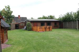 a backyard with a wooden fence and a house at Haus Seerobbe-Blockhaus im Garten in Fehmarn