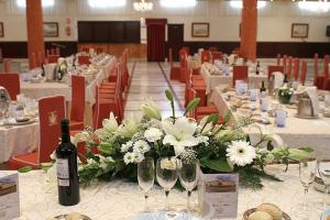 a room with tables with wine glasses and flowers at Hotel Begoña Park in Gijón
