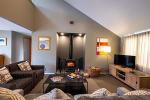 a living room with a couch and a fireplace at *** LAKE VILLA 457 *** in Hanmer Springs