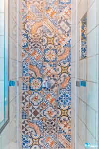 a tiled wall in a bathroom with a tile floor at Hotel Eunymos in Panarea