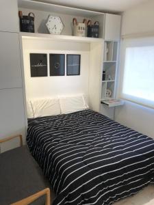 1 dormitorio con cama de rayas en blanco y negro en Emerald Apart Microcentro en Buenos Aires