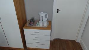ein kleiner Schrank mit weißen Schubladen in einem Zimmer in der Unterkunft Harlinger Lodge in London
