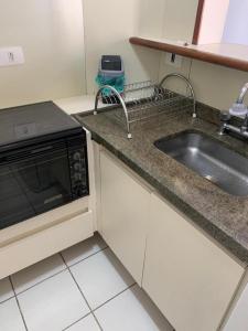 a kitchen with a sink and a microwave at Apto aconchegante ao lado do Shopping Pamplona, Jardim Paulista. in São Paulo