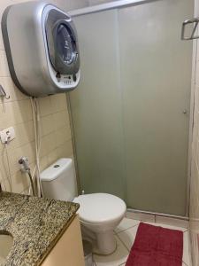 a bathroom with a toilet and a shower with a tv at Apto aconchegante ao lado do Shopping Pamplona, Jardim Paulista. in São Paulo