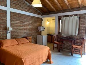 ein Schlafzimmer mit Bett und Schreibtisch und eine Küche in der Unterkunft Cabañas Bosques del Centro in Mina Clavero + 20 Fotos