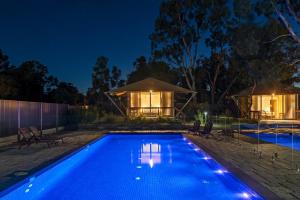 a swimming pool in front of a house at night at Discovery Parks - Barossa Valley in Tanunda
