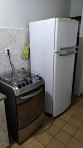 Il comprend une cuisine équipée d'une cuisinière et d'un réfrigérateur blanc. dans l'établissement Casa com Piscina 200 m da Praia - São Sebastião, à São Sebastião