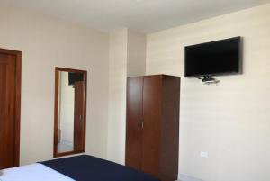 1 dormitorio con 1 cama y TV de pantalla plana en la pared en Hotel Arena Blanca, en Salinas