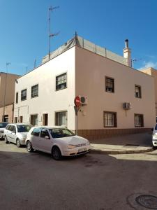 un coche blanco estacionado frente a un edificio en Casa Albeniz., en Algeciras