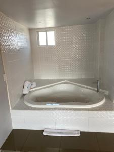 a bath tub sitting next to a sink in a bathroom at Hotel Aqua Rio in Tijuana