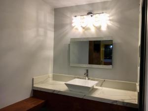 a bathroom with a mirror and a sink at Hotel Aqua Rio in Tijuana