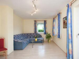 a living room with a blue couch and a window at Apartment in Altenmarkt in Pongau near ski area in Altenmarkt im Pongau