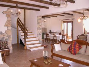 sala de estar con sofá y chimenea de piedra en Crete Family Villas en Pentamodi