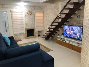 a living room with a blue couch and a tv at Chalé Centro de Monte Verde in Monte Verde
