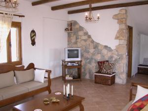 a living room with a couch and a tv at Crete Family Villas in Pentamodi