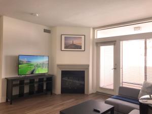 sala de estar con TV y chimenea en "Resort Style amenities walk to UCLA" w Pool & Parking B2 en Los Ángeles