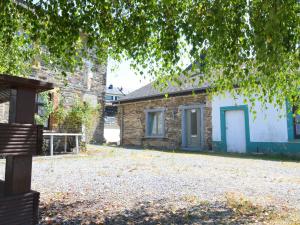 a stone house with a tree in front of it at Lovely Cottage in Alle with Garden in Alle