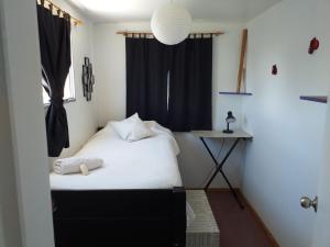 Dormitorio pequeño con cama y ventana en Bluetres B&B, en Balneario Buenos Aires