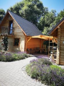 eine Holzhütte mit einer Veranda und einer Terrasse in der Unterkunft Domki Polanica in Polanica-Zdrój