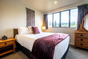 Un dormitorio con una cama grande y una ventana. en *** LAKE VILLA 461 ***, en Hanmer Springs