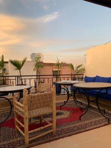 a patio with tables and chairs on a balcony at Terrace House in Marrakesh
